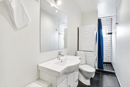 a white bathroom with a sink and a toilet at Just Sleep in Esbjerg