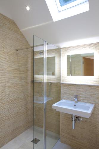 a bathroom with a sink and a glass shower at Railway Apartments in Nailsworth