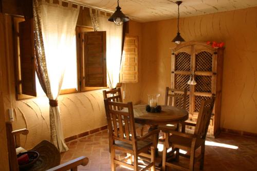 Casa rural eras de pantrillar في Ciruelas: غرفة طعام مع طاولة وكراسي خشبية