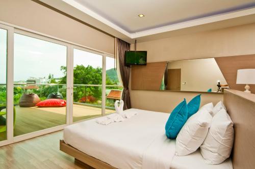 a bedroom with a large bed and a large window at Ratana Platinum Resort Kamala in Kamala Beach