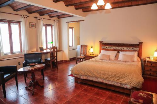 1 dormitorio con cama, escritorio y mesa en Hotel Boutique La Posada en Sucre