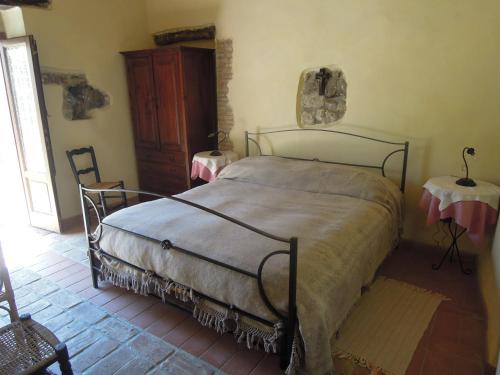 ポリッツィ・ジェネローザにあるAgriturismo Cucaのベッドルーム1室(ベッド1台、テーブル2台付)