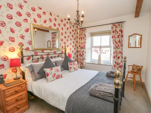 a bedroom with a large bed and a mirror at Middle Cottage in Leyburn