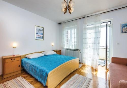 ein Schlafzimmer mit einem großen Bett mit einer blauen Decke in der Unterkunft Apartment Dari - with terrace in Lovran