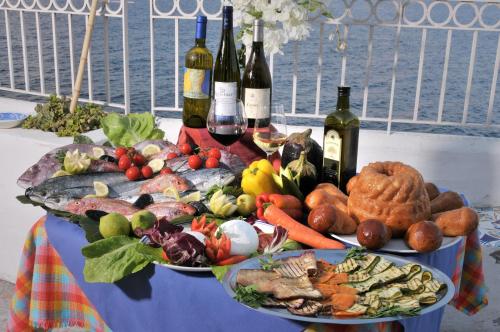a table with two plates of food and bottles of wine at Hotel Villaggio Stromboli - isola di Stromboli in Stromboli