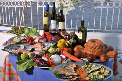 a table with two plates of food and bottles of wine at Hotel Villaggio Stromboli - isola di Stromboli in Stromboli