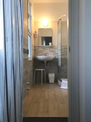 a bathroom with a sink and a toilet and a mirror at Hotel Augustus in Milano Marittima