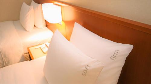 a hotel room with two pillows on a bed at ANA Holiday Inn Sendai by IHG in Sendai