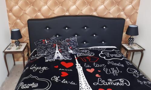 a bed with a black comforter with the words paris at Apartament centrum Sienkiewicza WIEŻA EIFFLA PROMENADA -KLIMATYZACJA- WYJĄTKOWY in Kielce