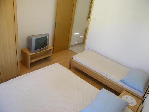 a small room with two beds and a tv at Apartments Fran-30m from sea in Vinišće