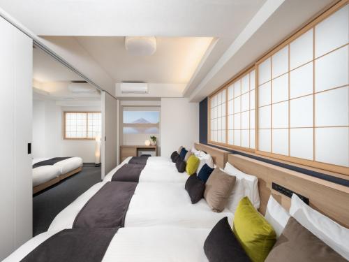 a row of beds in a hotel room at MIMARU Tokyo Shinjuku West in Tokyo