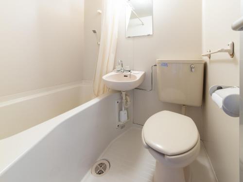 a white bathroom with a toilet and a sink at Tabist Tatsumi Business Hotel Matsusaka in Matsuzaka