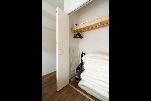 a small room with a bed and a closet at Eims stay Oomori304 in Tokyo