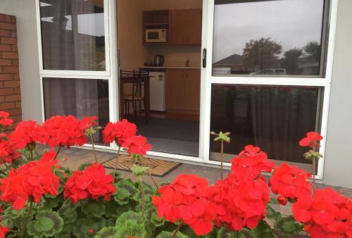 Un mazzo di fiori rossi davanti a una porta di Avon City Motel a Christchurch