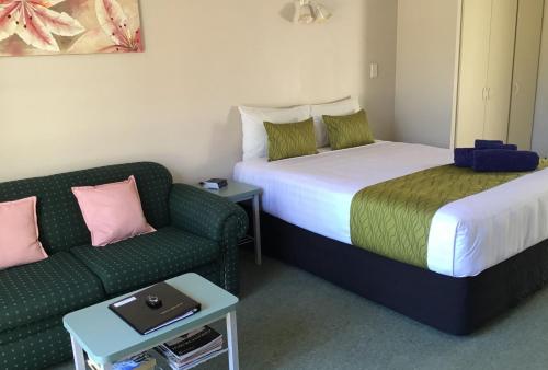 a hotel room with two beds and a couch at Avon City Motel in Christchurch