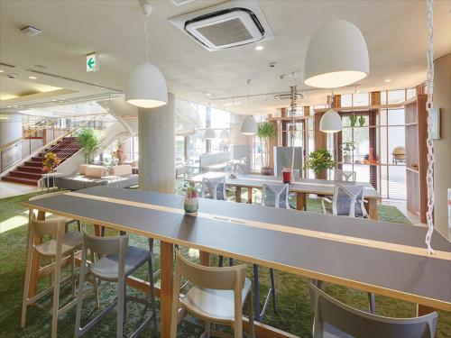 duża jadalnia z dużym stołem i krzesłami w obiekcie Hotel Yugaf Inn Okinawa w mieście Nago