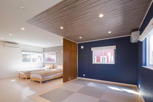 a living room with a bed and a blue wall at 雲 - Family House KUMO - in Shirahama