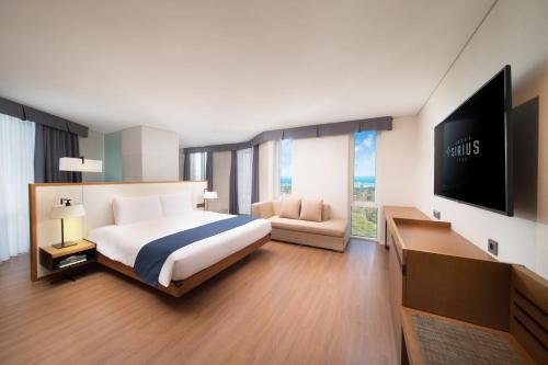 a bedroom with a bed and a flat screen tv at Hotel Sirius in Jeju