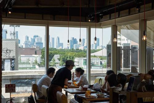 a group of people sitting at tables in a restaurant at Annex Shibuya in Tokyo