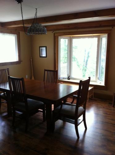 a dining room with a wooden table and chairs at Seymour Point Cottage in Campbellford
