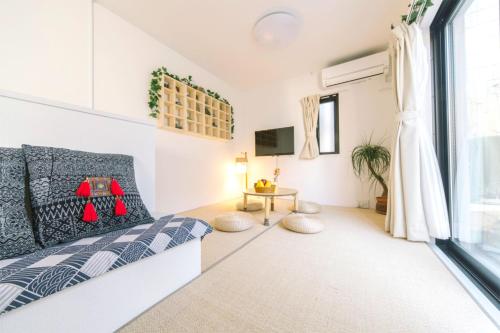 Schlafzimmer mit einem Bett, einem TV und einem Fenster in der Unterkunft nestay inn tokyo kagurazaka 01 in Tokio