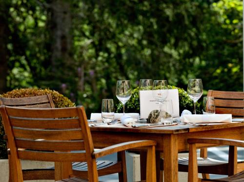 a wooden table with wine glasses on top of it at Hotel und Naturresort Handeck in Guttannen