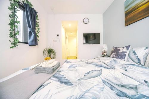a bedroom with a large bed with blue and white sheets at nestay inn tokyo kagurazaka in Tokyo