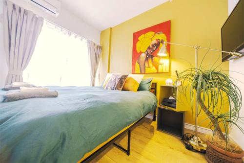 a bedroom with a bed and a painting on the wall at nestay inn tokyo kagurazaka in Tokyo