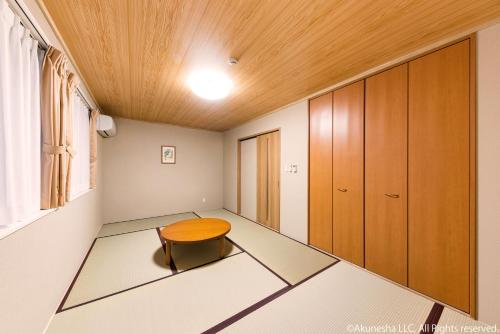a room with a table and a wooden ceiling at Oyado Midokoi in Akune