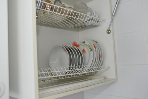 um suporte para pratos com pratos e pratos num frigorífico em Apartment Horkoho 7A em Shostka