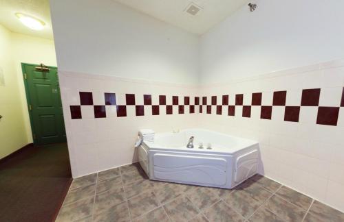 a bathroom with a bath tub in a room at Country Inn & Suites by Radisson, Indianapolis South, IN in Indianapolis