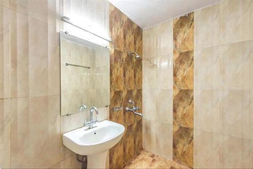ein Bad mit einem Waschbecken und einem Spiegel in der Unterkunft Hotel Jaya International in Hyderabad