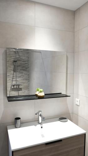 a white bathroom with a sink and a mirror at Casa Peppina - Chez Tonio et Sylvie in Sari Solenzara