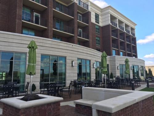 a building with tables and chairs and green umbrellas at Holiday Inn Paducah Riverfront by IHG in Paducah