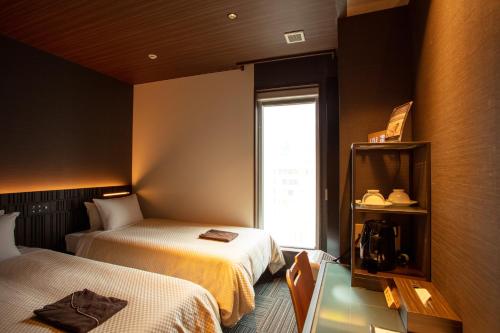 a hotel room with two beds and a window at JHotelTokyoGEO in Tokyo