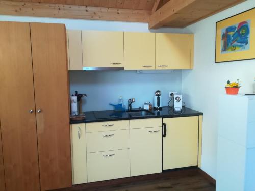 una cocina con armarios blancos y fregadero en Montanara en Meiringen