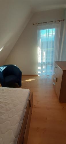 a bedroom with a bed and a desk and a window at Domek Rokitki in Rokity