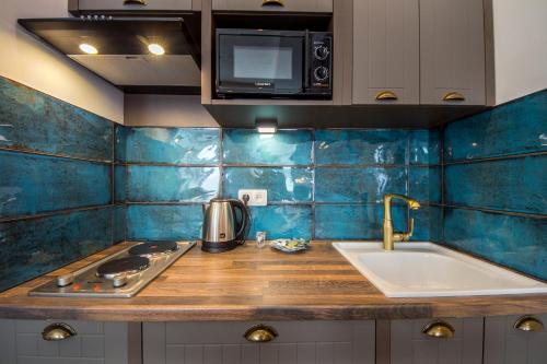a kitchen with a sink and a stove and a microwave at Central Dayflat Apartments in Kyiv