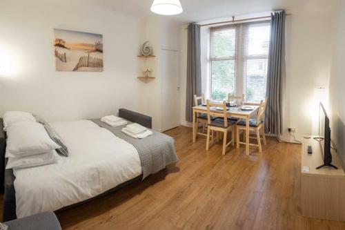 een slaapkamer met een bed en een eettafel bij ☆ Quiet Ground Floor Apartment Near University ☆ in Dundee