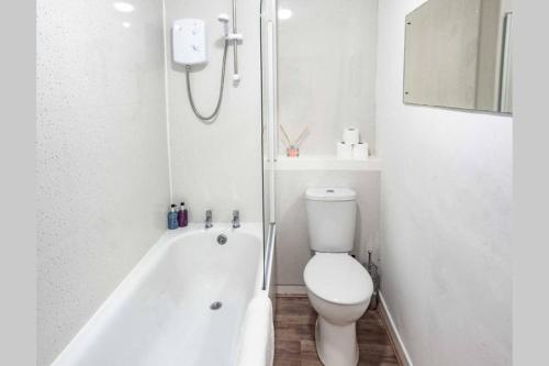 a white bathroom with a toilet and a bath tub at ☆ Quiet Ground Floor Apartment Near University ☆ in Dundee