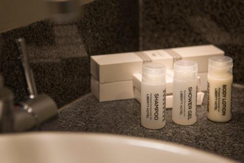a group of four bottles sitting on a bathroom counter at Liberty Hotel Thamrin Jakarta in Jakarta