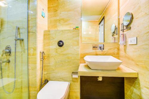 La salle de bains est pourvue d'un lavabo et d'une douche. dans l'établissement The Hotel Orient Taibah, à Nagpur