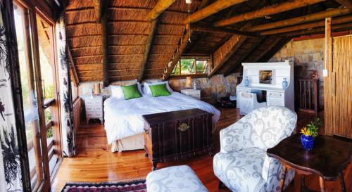 um quarto com uma cama e uma cadeira num quarto em Scarborough Nature Lodge em Cidade do Cabo