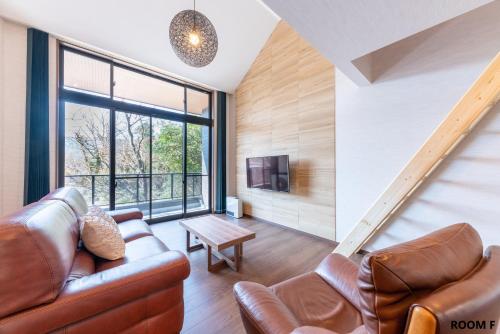 a living room with a couch and a tv at VILLA HAKONE STAGE in Hakone