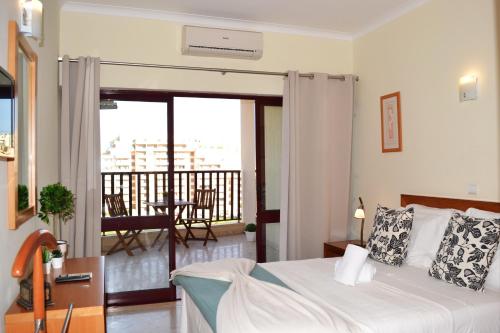 Un dormitorio con una cama y un balcón. en Clube Praia Mar Flats, en Portimão