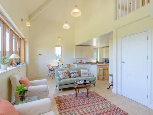 ein Wohnzimmer mit einem Sofa und einem Tisch in der Unterkunft Mulberry Barn Annx - Self Contained Near Winchester in Micheldever