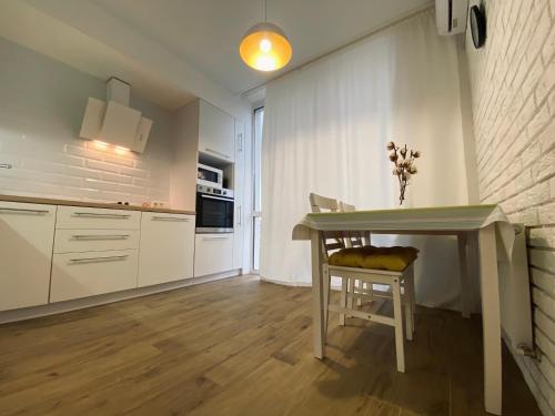 a kitchen with a table and a chair in a room at Scandinavian apartment на Марсельской in Kryzhanivka