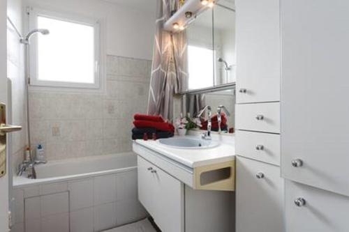 ein Badezimmer mit einem Waschbecken, einer Badewanne und einem Spiegel in der Unterkunft REFAIT A NEUF Appartement proche de Paris in Asnières-sur-Seine