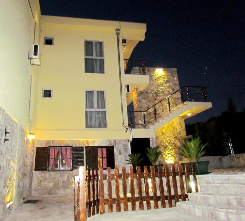 a house with a fence in front of it at night at Hotel Crnogorska Kuća in Podgorica