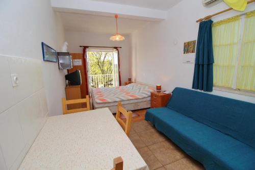 a living room with a blue couch and a bed at Apartments Felix in Babino Polje